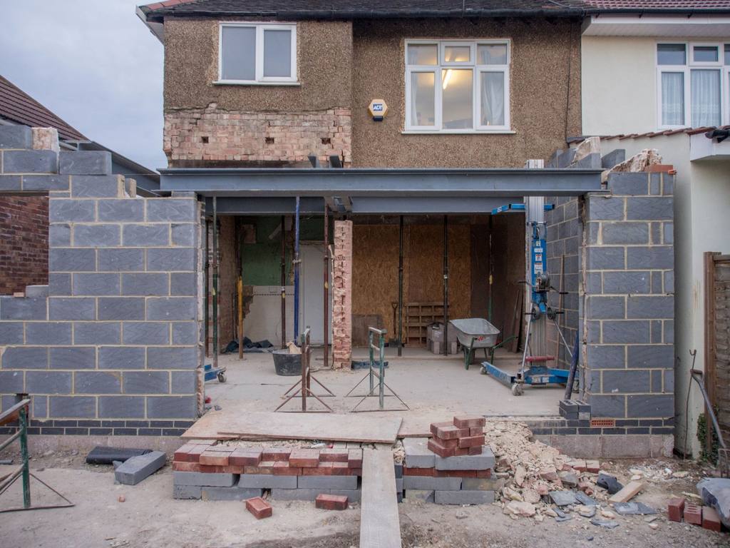 Brick semi-detached house with a blockwork rear extension under construction